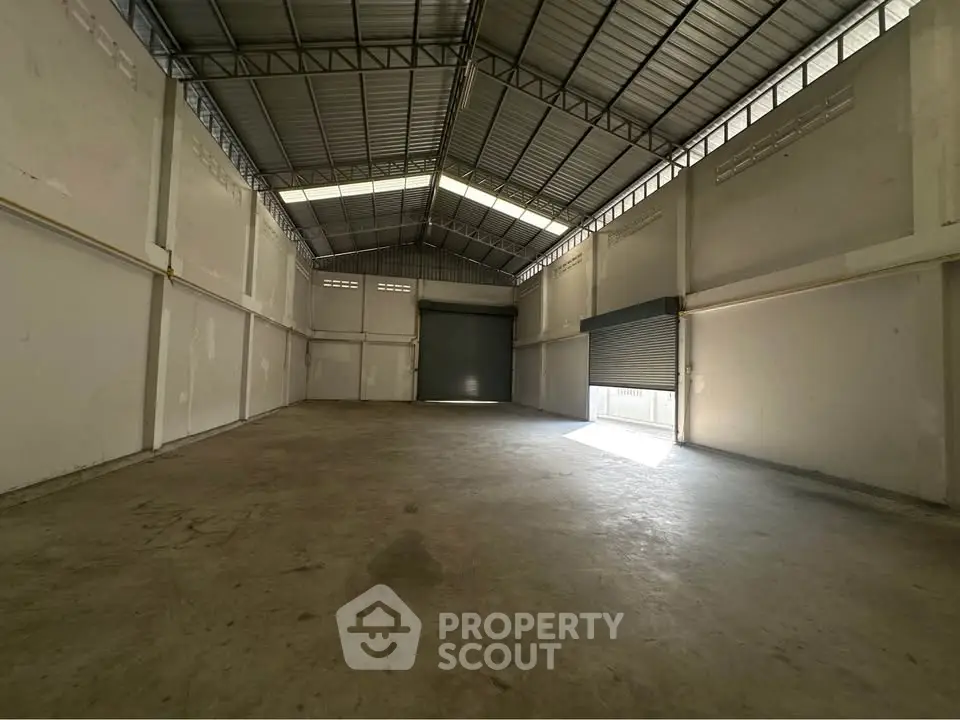 Spacious industrial warehouse with high ceilings and large roller doors