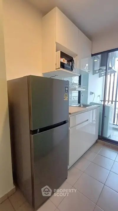 Modern kitchen with sleek appliances and balcony view