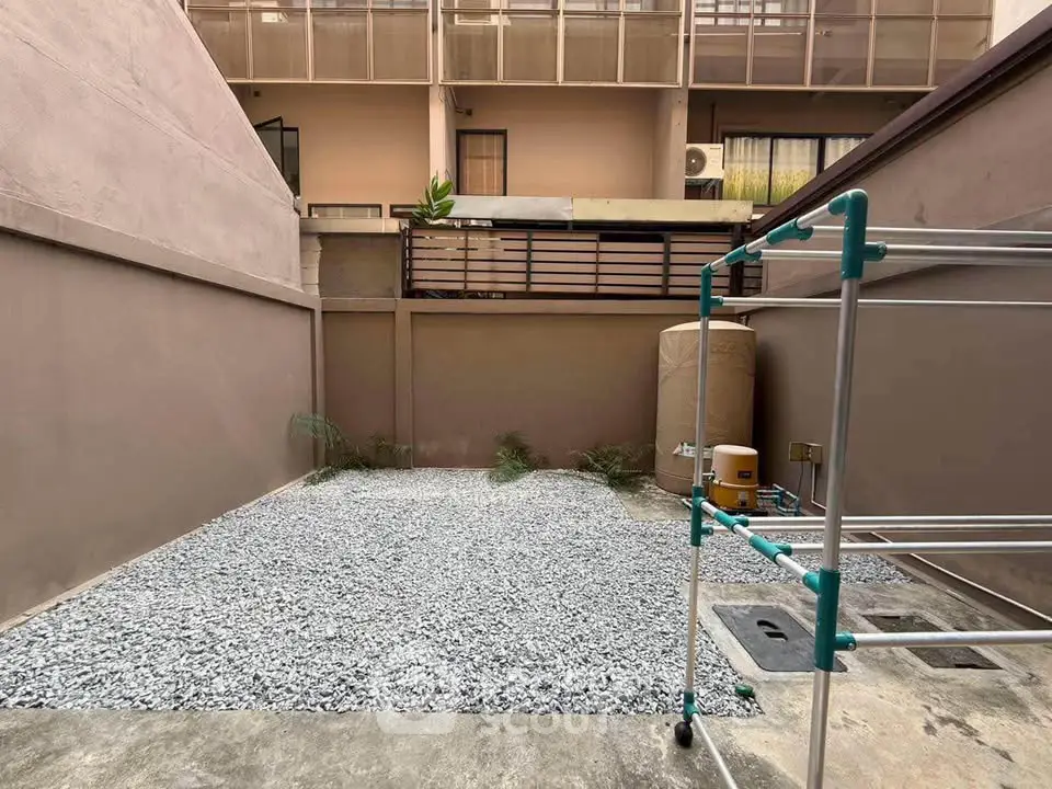 Spacious outdoor area with gravel and modern architecture, perfect for urban living.