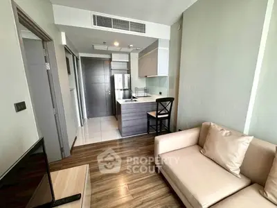 Modern living room with open kitchen and cozy seating area in a stylish apartment.