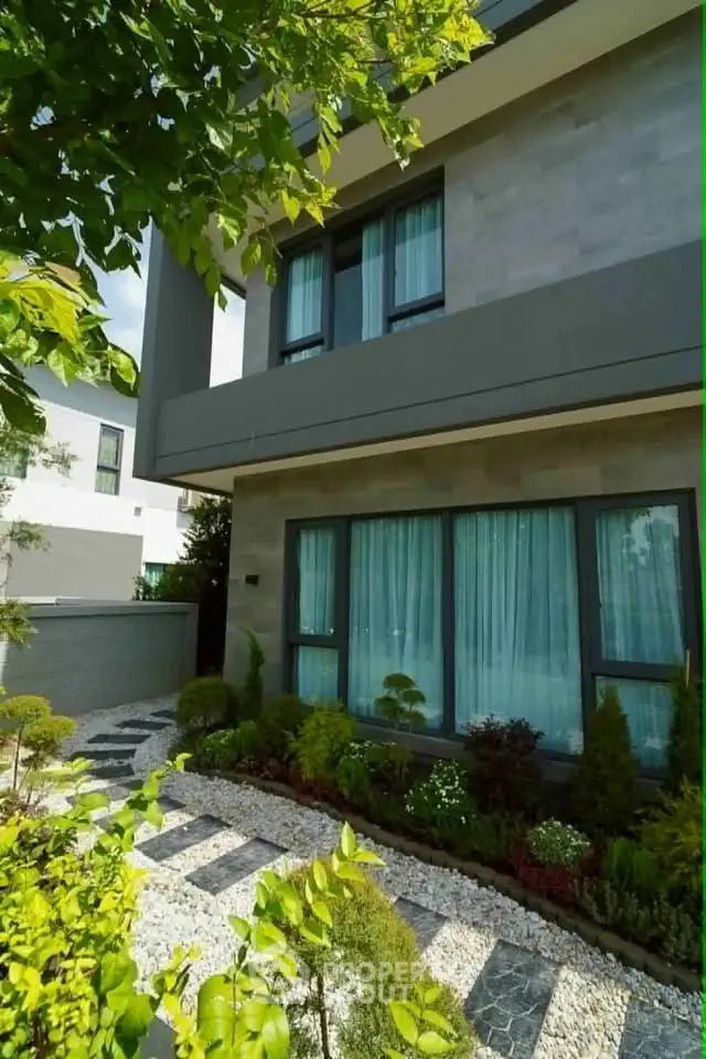 Modern two-story house with landscaped garden and large windows