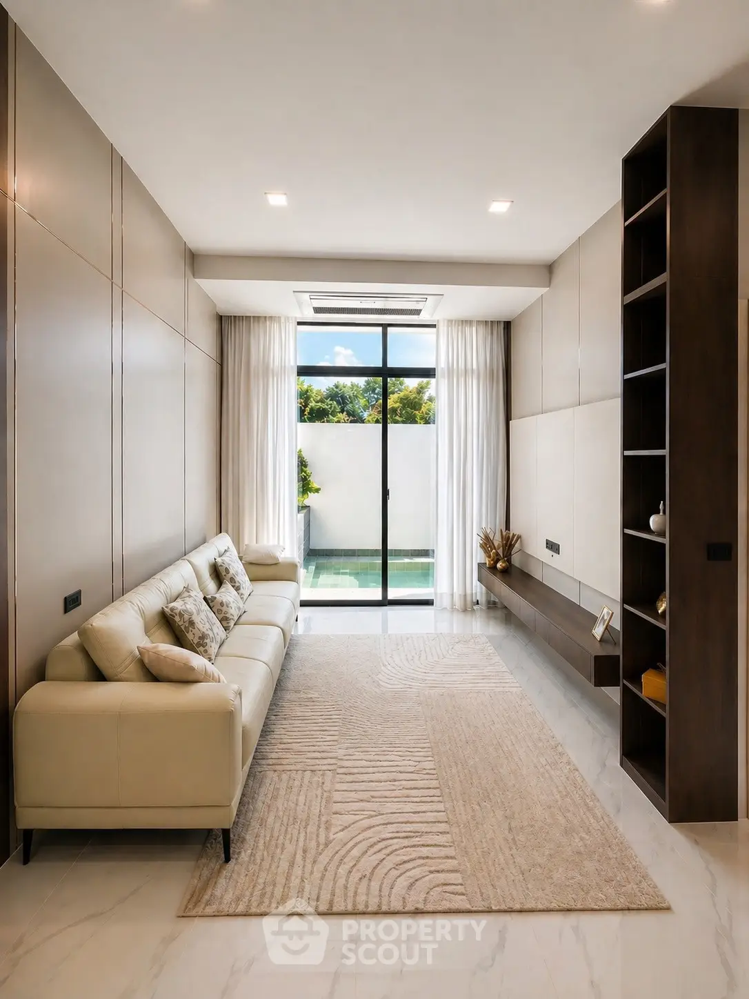 Luxurious living room with modern decor and pool view, featuring elegant sofa and floor-to-ceiling windows.