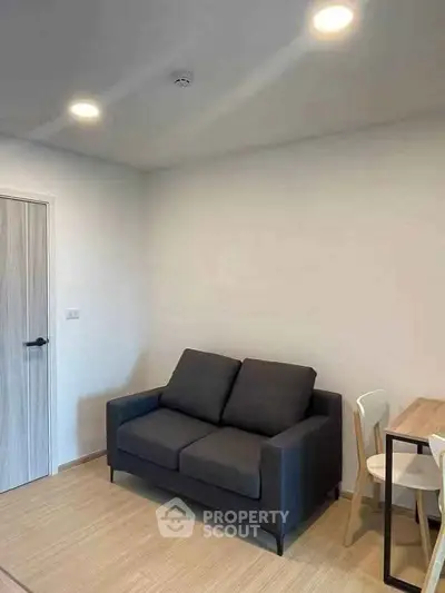 Cozy living room with modern sofa and dining area in a minimalist apartment.