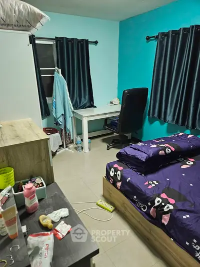 Cozy bedroom with vibrant decor and study area, perfect for comfortable living.