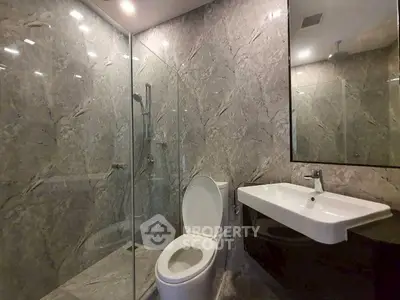 Luxurious marble bathroom with modern fixtures and glass shower enclosure