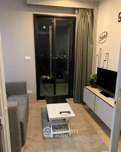 Modern living room with city view, sleek furniture, and cozy ambiance.