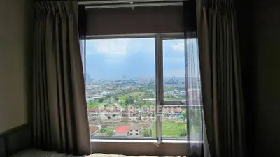 Stunning cityscape view from a cozy bedroom window, perfect for urban living.
