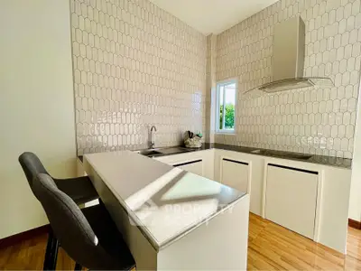 Modern kitchen with sleek design and open layout, featuring a stylish breakfast bar and contemporary appliances.