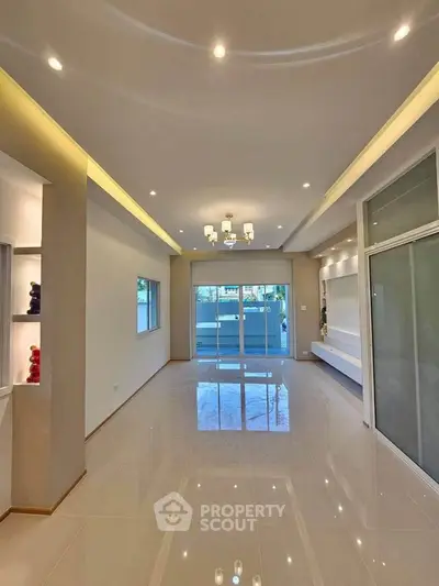 Spacious modern living room with elegant lighting and large windows for natural light.