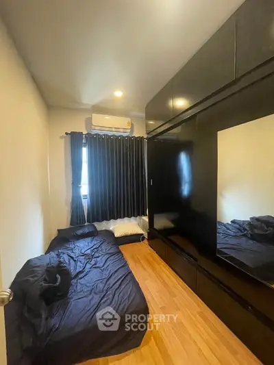 Cozy bedroom with black decor and wooden flooring