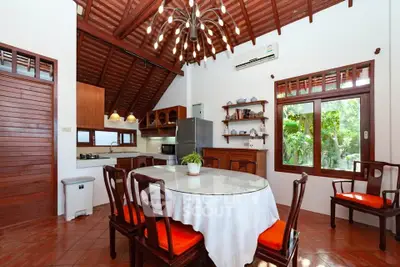 Charming kitchen with open layout, wooden ceiling, and garden view, perfect for cozy family gatherings.