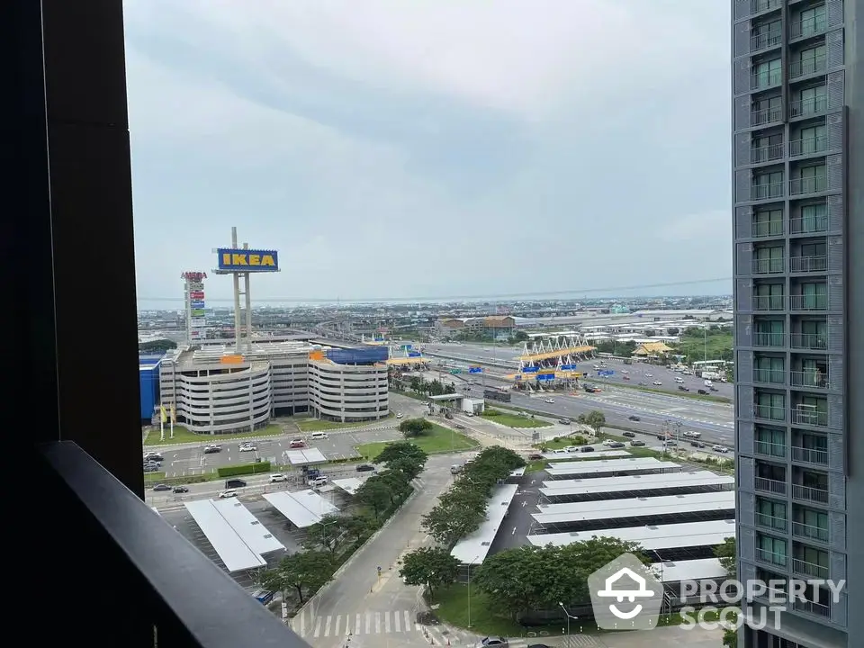 Stunning cityscape view from high-rise balcony near IKEA and major highway.