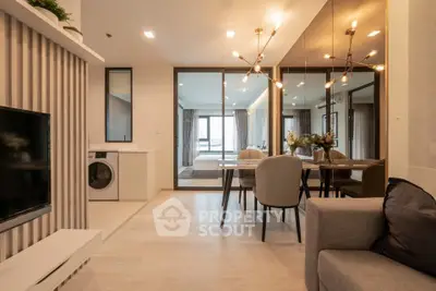 Modern open-plan living room with dining area and glass partition leading to bedroom.