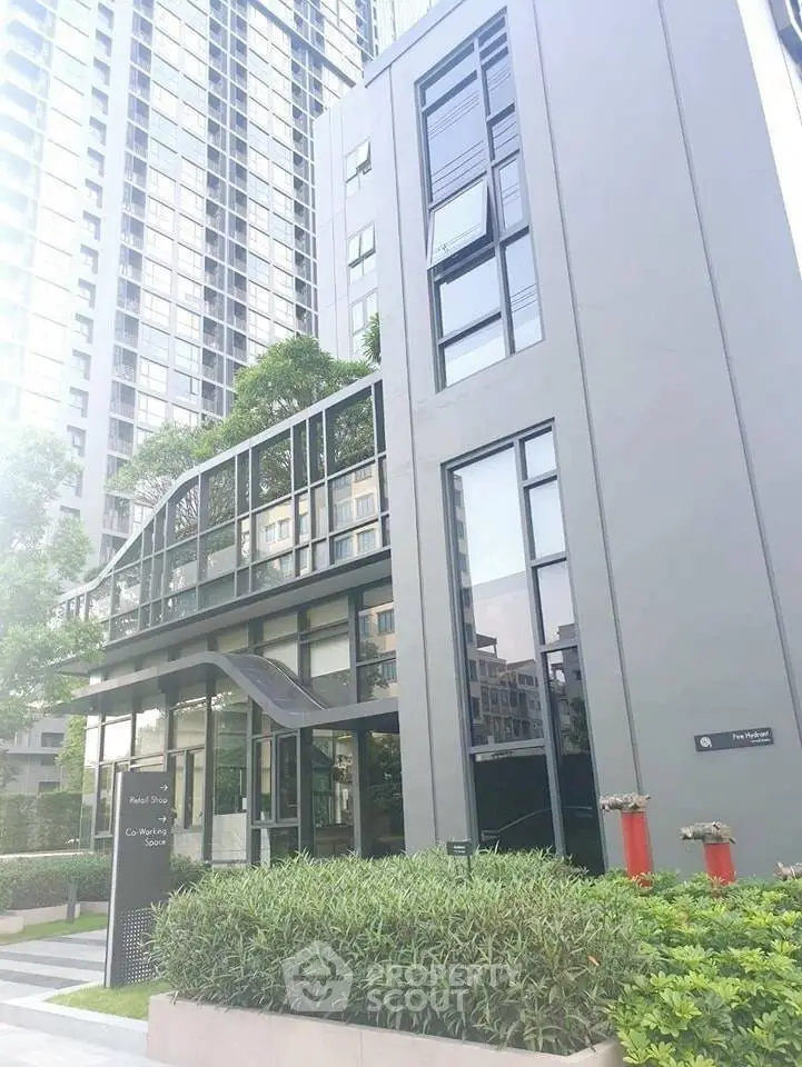 Modern high-rise building exterior with sleek design and lush greenery.