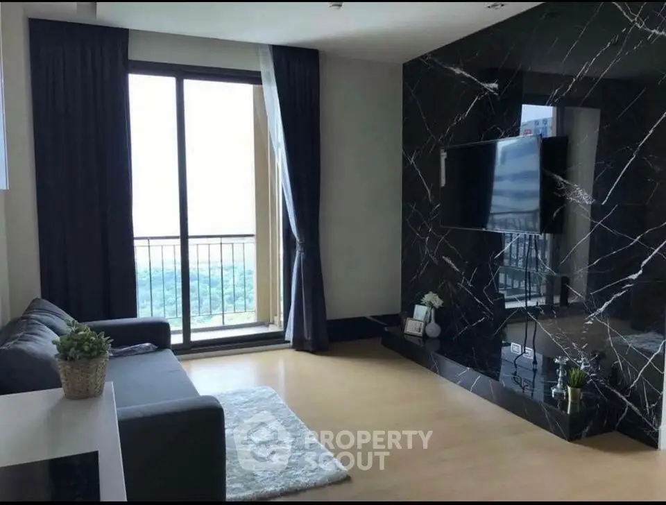 Modern living room with sleek black marble wall and large window offering stunning view.