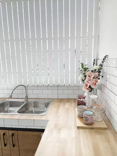 Charming kitchen with wooden countertops and dual sink, featuring elegant floral decor and natural light.