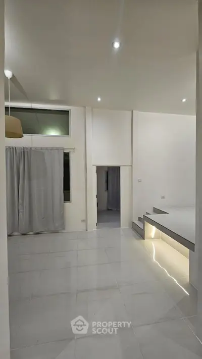 Spacious modern living room with sleek tile flooring and ambient lighting