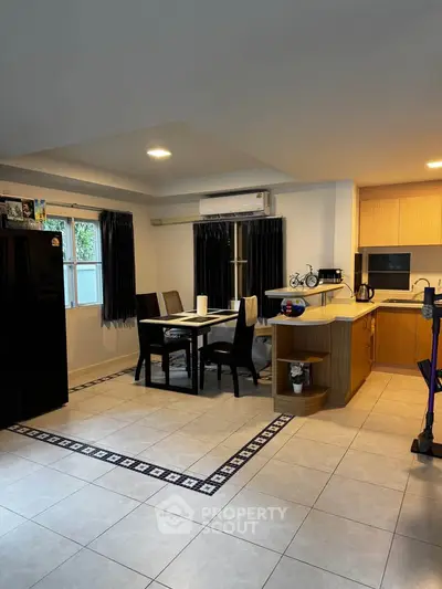 Spacious kitchen with dining area and modern appliances in a cozy home setting.
