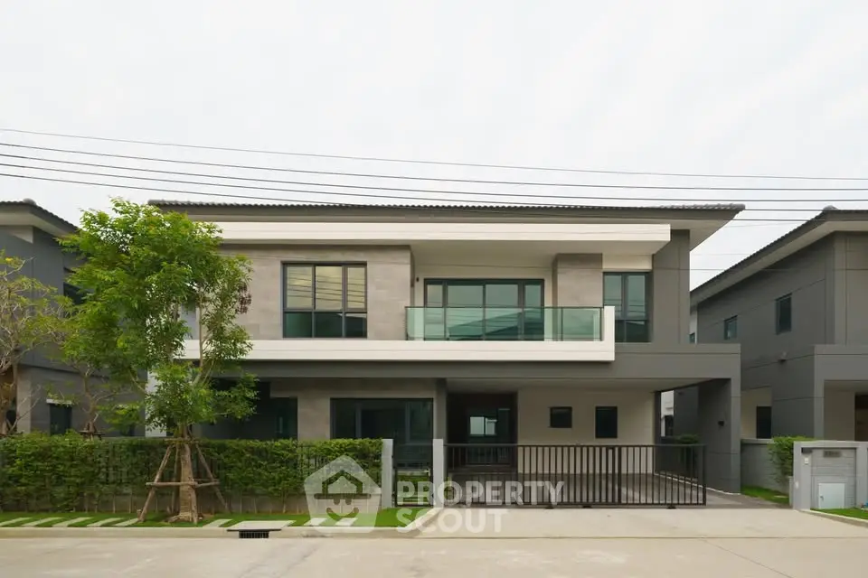 Modern two-story house with sleek design and spacious driveway in a suburban neighborhood.