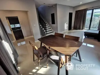 Modern dining area with sleek wooden table and chairs, open layout, and natural light.