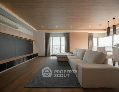 Spacious modern living room with elegant wooden flooring and large windows.