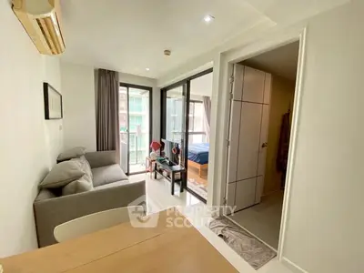 Modern apartment interior with open living room and bedroom, featuring large windows and stylish decor.