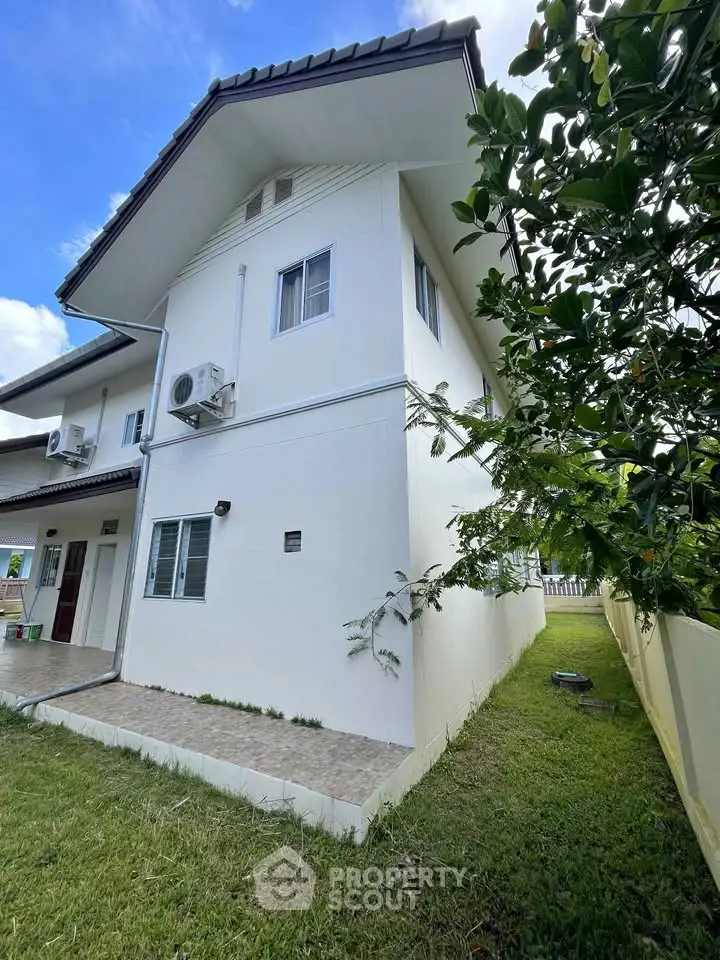 Charming two-story house with lush garden and modern exterior design, perfect for family living.