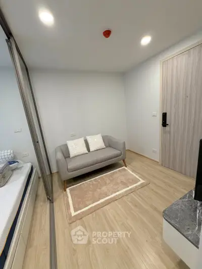 Modern small living area with cozy sofa and stylish decor in a compact apartment.