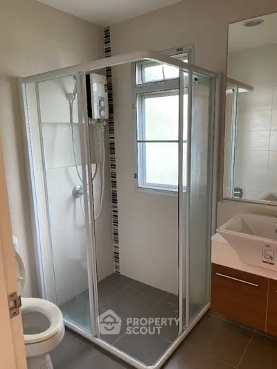 Modern bathroom with glass shower enclosure and sleek vanity unit