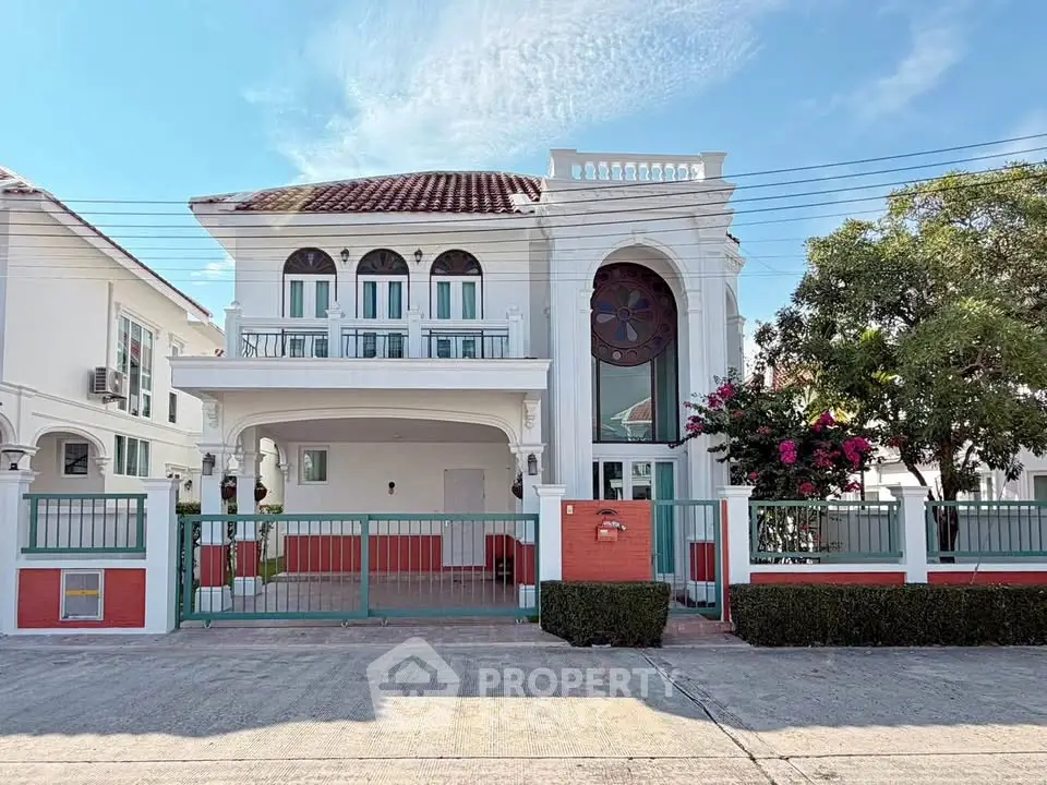 Elegant two-story house with classic architecture and lush garden in a serene neighborhood.