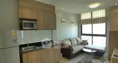 Modern living room with kitchenette and large window in a cozy apartment