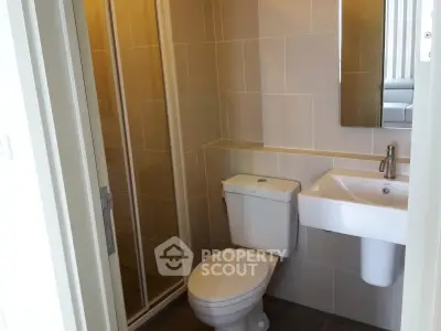 Modern bathroom with sleek fixtures and a glass-enclosed shower in a contemporary apartment.