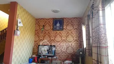 Charming living room with elegant wallpaper and natural light, perfect for cozy family gatherings.