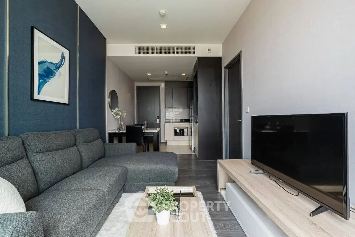 Modern living room with sleek furniture and open kitchen layout in a stylish apartment.