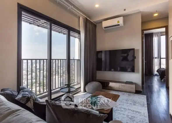 Modern living room with city view, large TV, and stylish decor.
