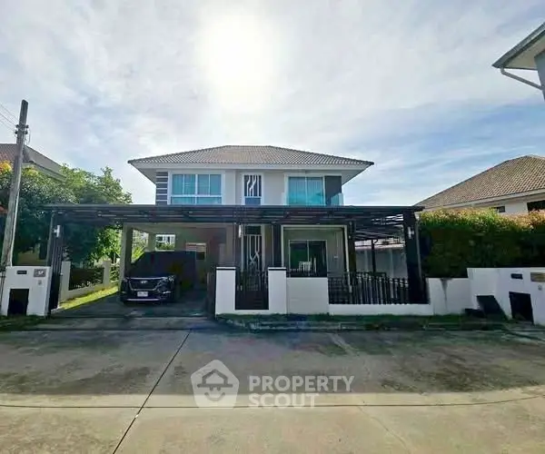 Modern two-story house with carport and well-maintained front yard in a suburban neighborhood.