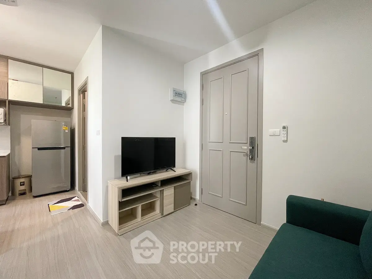 Modern living room with sleek design, featuring a TV stand, flat-screen TV, and stylish furniture in a cozy apartment.