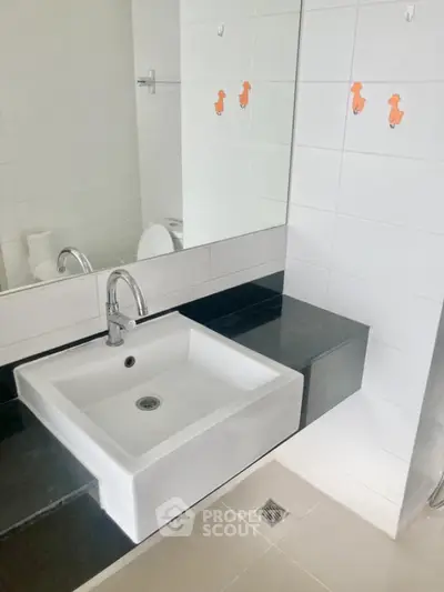 Modern bathroom with sleek sink and large mirror in contemporary home.