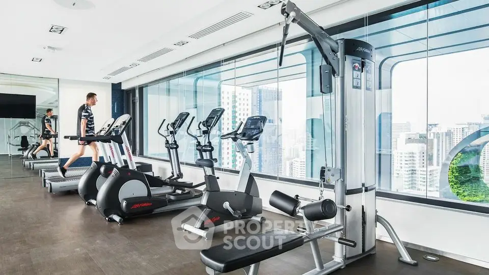 Modern gym with city view, featuring state-of-the-art fitness equipment and sleek design.