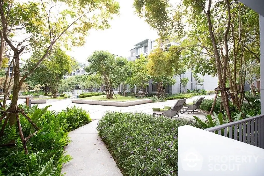 Tranquil garden oasis within a modern residential complex, featuring lush landscaping, serene pathways, and comfortable outdoor seating areas.