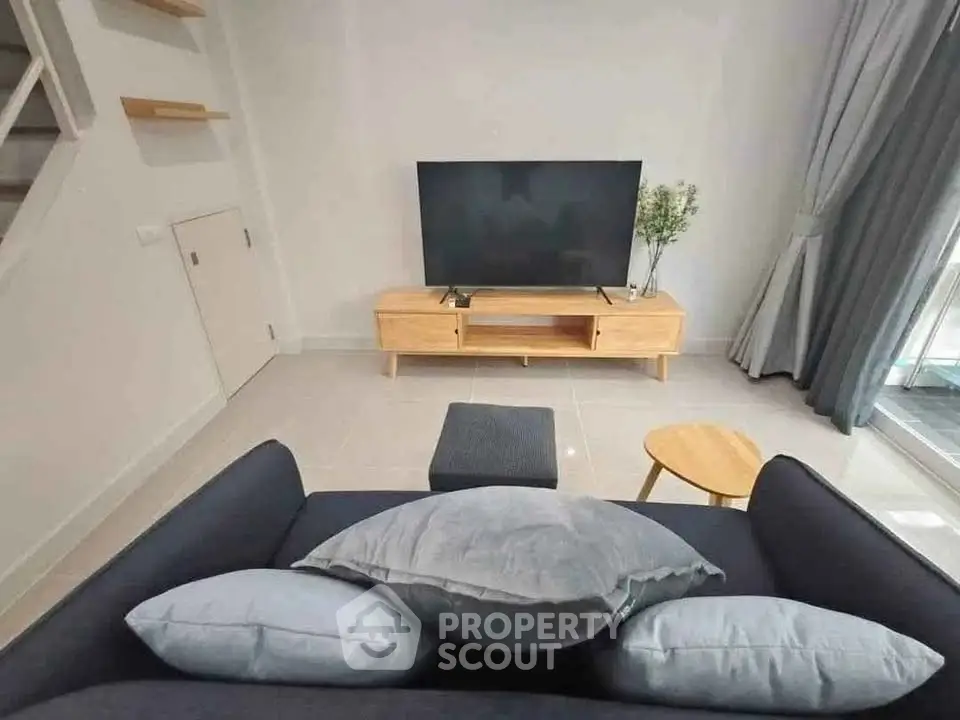 Modern living room with sleek TV setup and cozy sofa arrangement.