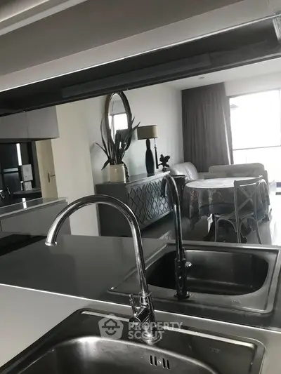 Modern kitchen with sleek faucet and open layout overlooking stylish dining area.