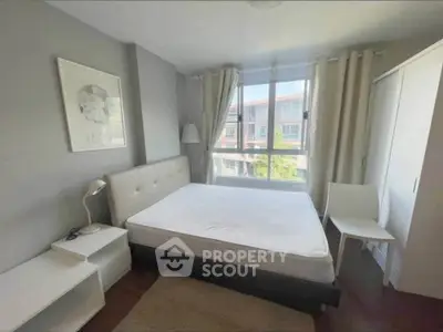 Bright and cozy bedroom with large window and modern furnishings