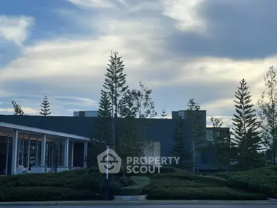Modern architectural building with lush landscaping and dramatic sky