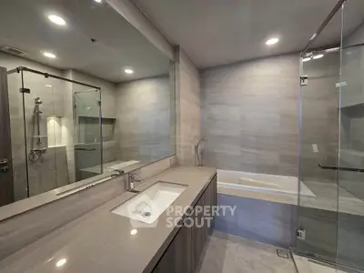 Luxurious modern bathroom with sleek design, featuring a glass shower and elegant bathtub.
