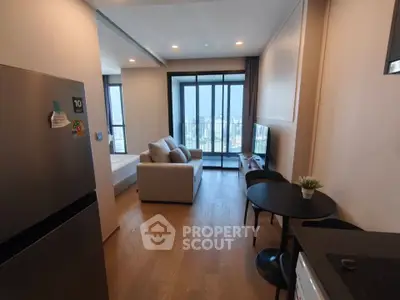 Modern open-plan living room with city view, featuring sleek furniture and natural light.