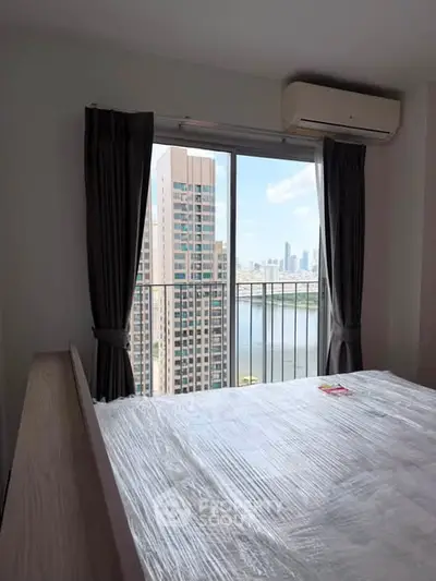 Modern bedroom with stunning city view from high-rise apartment window.