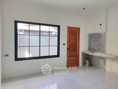 Minimalist kitchen space with large window and wooden door