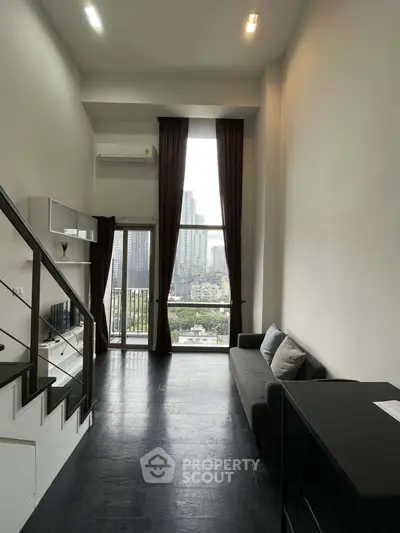 Modern loft apartment with high ceilings and city view from large windows.