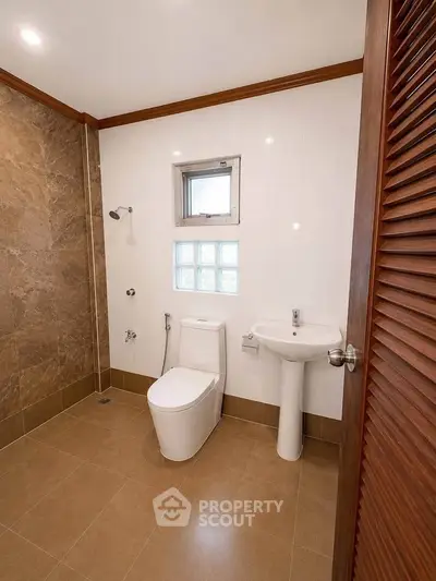 Spacious modern bathroom with elegant tile design and natural light.